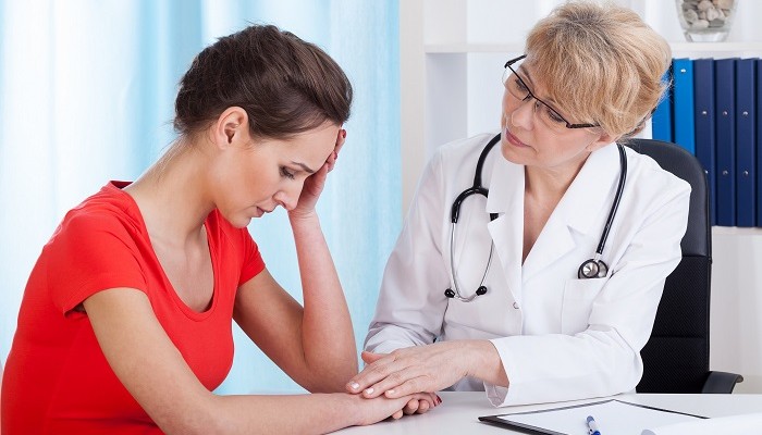 Female doctor with depressed young patient, horizontal