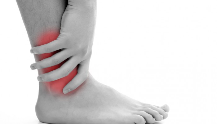 Young man having pain in his ankle